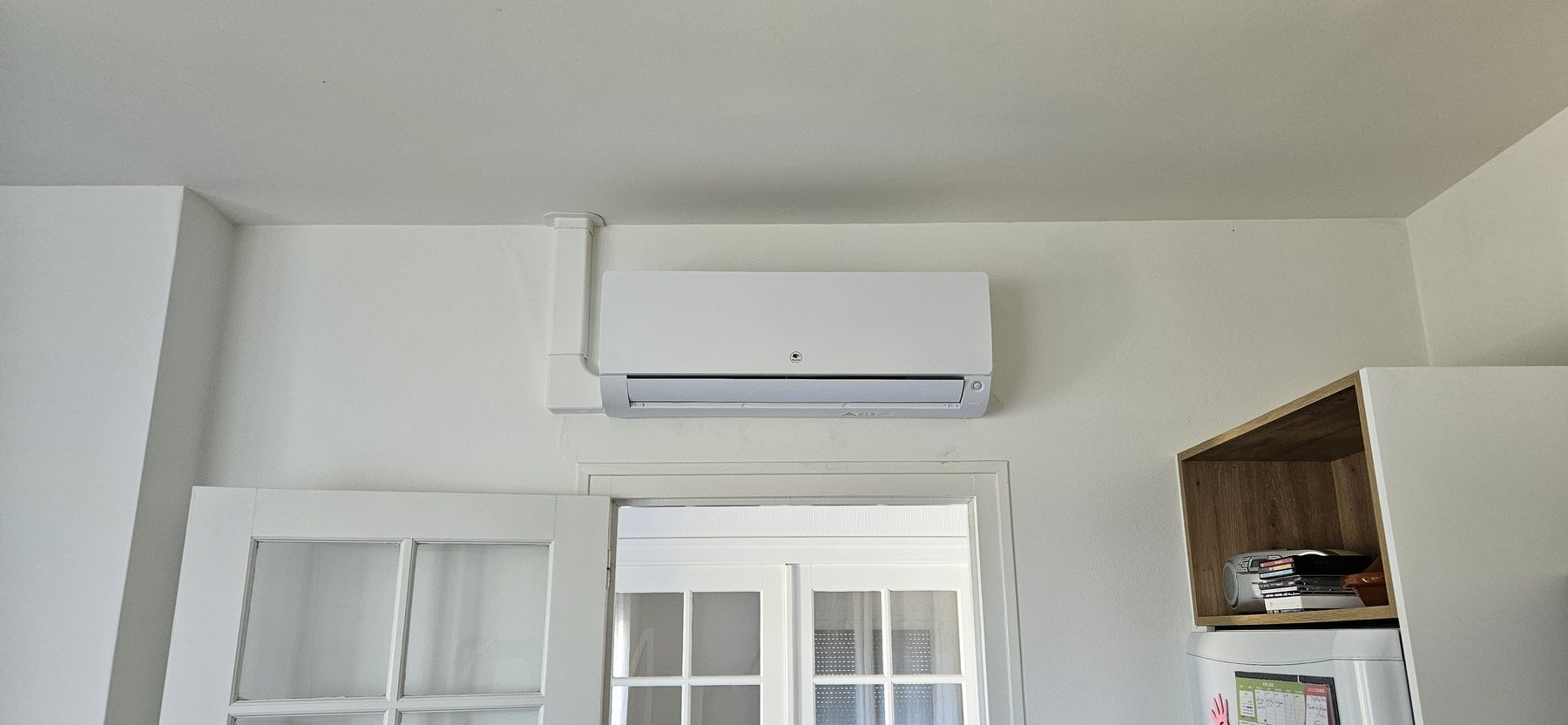 Climatisation murale installée au-dessus d’une porte